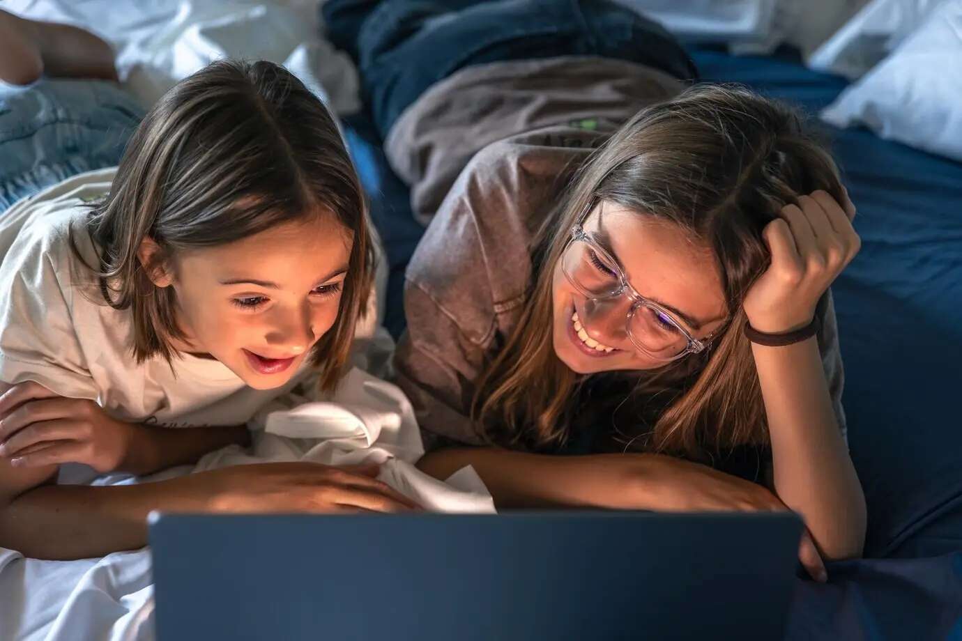 Zwei Mädchen lachen vor dem Bildschirm, lockere Stimmung, fröhliches Mädchen.